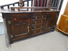 An 18th century oak dresser base having 4 central drawers flanked by cupboards, 181cm