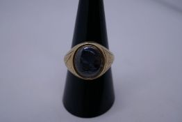 9ct yellow gold gents signet ring with a grey panel, etched with the face of a man, engraved floral