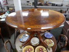 A circular reproduction dining table having painted decoration on quadropod base by Restall Brown an