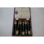 A cased set of six sterling silver teaspoons with decorative fonate patterns on the handles.