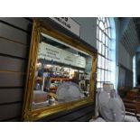 A modern gilt wall mirror having beveled glass