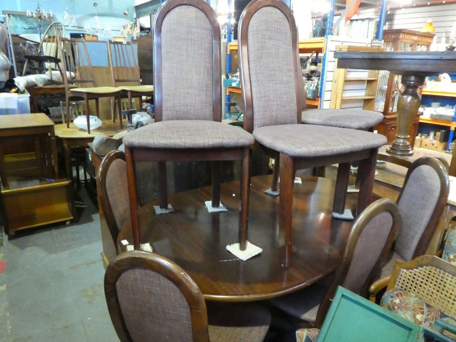 A modern 1970's style extenders dining table and a set of eight matching chairs