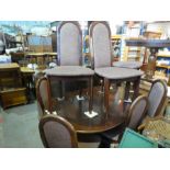 A modern 1970's style extenders dining table and a set of eight matching chairs