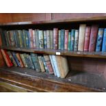 Two shelves of old books having decorative spines including, 'Stories from the Arabian Nights' by Ed