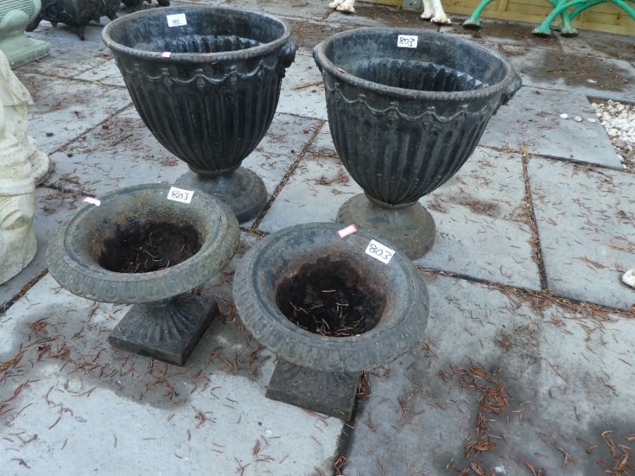 Pair of Victorian style cast iron garden urns on circular base and smaller pair on square bases