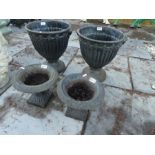 Pair of Victorian style cast iron garden urns on circular base and smaller pair on square bases