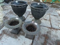 Pair of Victorian style cast iron garden urns on circular base and smaller pair on square bases