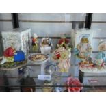 Two shelves of mixed collectable figures including Rupert, Beatrix Potter etc.