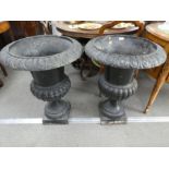 A pair of Victorian black painted cast iron urns on square base, height 77cms