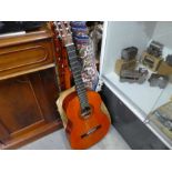 An accoustic guitar in a case made by Barnes & Mullins, plus a blue rug