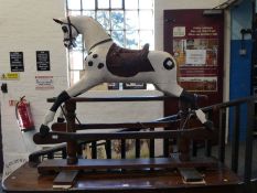 A Victorian painted rocking horse having leather saddle on pine base, 145cm long