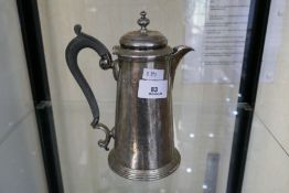 A silver Victorian coffee pot in a raised foot with ebonised wood handle. Hallmarked Sheffield 1899,