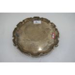A circular silver tray with engraved writing in the centre, surrounded by various signatures. Hallma