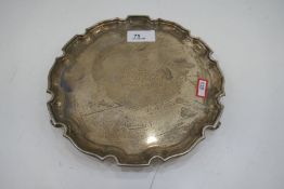 A circular silver tray with engraved writing in the centre, surrounded by various signatures. Hallma