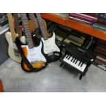 A large selection of various guitars, electric and accoustic and a small piano