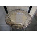 A decorative, hand pierced silver cake stand with a grapevine border. On a raised pedestal base. Hal