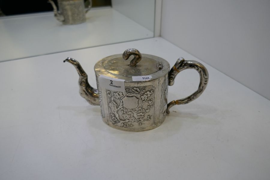 A Chinese teapot marked Kucheung with floreated design embossed on the body. Central vacant cafonche