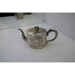 A Chinese teapot marked Kucheung with floreated design embossed on the body. Central vacant cafonche