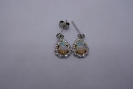 Pair of white gold drop earrings, with central pear shaped opals, with blue and green colour flashes