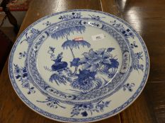 A Chinese 19th century blue and white charger, decorated flowers and vases, 35cms (hairline crack)