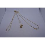 14K yellow gold fine neckchain together with a 14K necklace hung with a pendant in the form of an ap