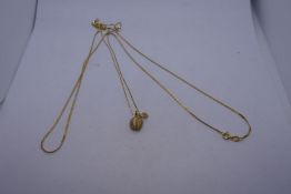 14K yellow gold fine neckchain together with a 14K necklace hung with a pendant in the form of an ap