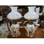 A pair of Sitzendorf porcelain oil lamps, each decorated with 3 cherubs 33.5cm