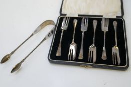 A silver pair of tongs hallmarked Dublin 1813, Samuel Neville. With a cased set of 6 silver cake for
