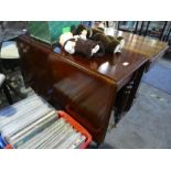 A Victorian mahogany two flap dining table and a modern armchair having show wood