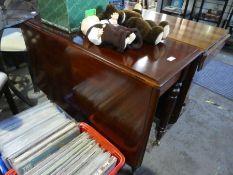 A Victorian mahogany two flap dining table and a modern armchair having show wood
