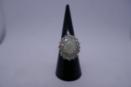 18ct white gold cluster ring, with central oval with opal approx 1cm, length 0.05 to 0.10 cara