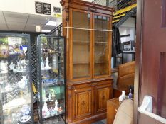 Gillows; a late Victorian Oak unlaid bookcase with pair of glazed doors and cupboard below (251cm hi