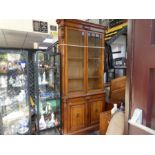 Gillows; a late Victorian Oak unlaid bookcase with pair of glazed doors and cupboard below (251cm hi