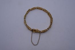 Unusual 15ct yellow gold gate link bracelet with turned central bar with safety chain, clasp in work