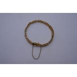 Unusual 15ct yellow gold gate link bracelet with turned central bar with safety chain, clasp in work