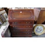 A reproduction mahogany bureau having four long drawers