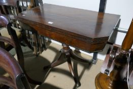 An antique mahogany foldover card table with ebony stringing on quadropod base