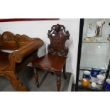 A Victorian mahogany hall chair having shaped back on turned front legs