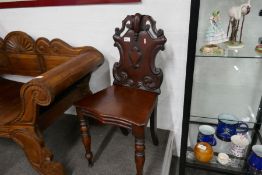A Victorian mahogany hall chair having shaped back on turned front legs