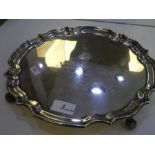 A large heavy silver tray of circular form, on three feet. Having engraved writing on the front. Hal