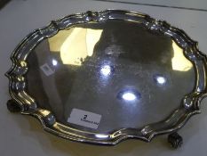 A large heavy silver tray of circular form, on three feet. Having engraved writing on the front. Hal