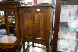 A small oak two door cupboard and two chairs and a five branch light