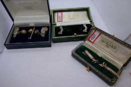 Three cased pairs of silver novelty cufflinks all of a golfing theme, and a 9ct yellow gold pin badg