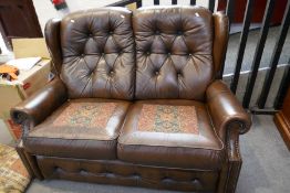 A modern brown leather 2 seat settee, having button back, 146cm