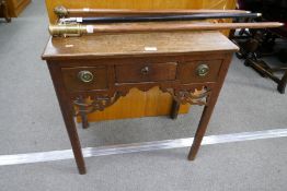 An antique oak low boy having three drawers on square chamfered legs