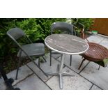 A metal Bistro table and two metal folding chairs