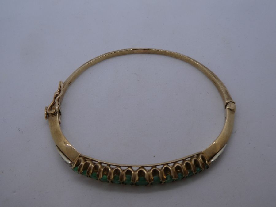 A 20th century 9ct yellow gold emerald and diamond hinged bangle comprising of thirteen round cut em - Image 2 of 5