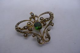 9ct yellow gold early Art Nouveau. Butterfly shaped pendant with central cushion cut emerald surroun