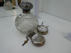 A silver topped cut glass spherical bottle, and two pocket watches, one marked 0.935 with engine tur