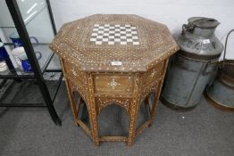 A Moorish octagonal table on folding base, with floral bone inlaid decoration and chess board top, 5